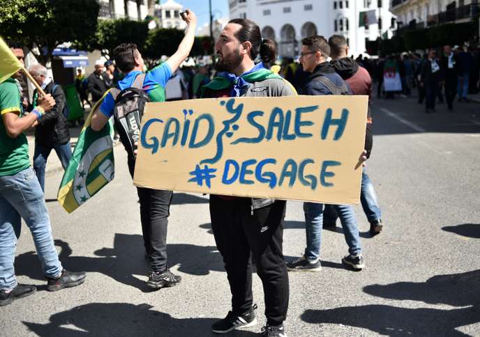 A protester holds a placard during a demonstration against ailing President Abdelaziz Bouteflika in the capital Algiers on March 29, 2019. - Opposition to Bouteflika has been widening since the chief of staff, General Ahmed Gaid Salah on March 26, 2019 invoked Article 102 of the constitution under which a president can be removed if found unfit to rule. (Photo by RYAD KRAMDI / AFP)